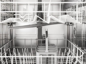 A black and white photo of the inside of a clean dishwasher without mold, food, or dirty dishes.