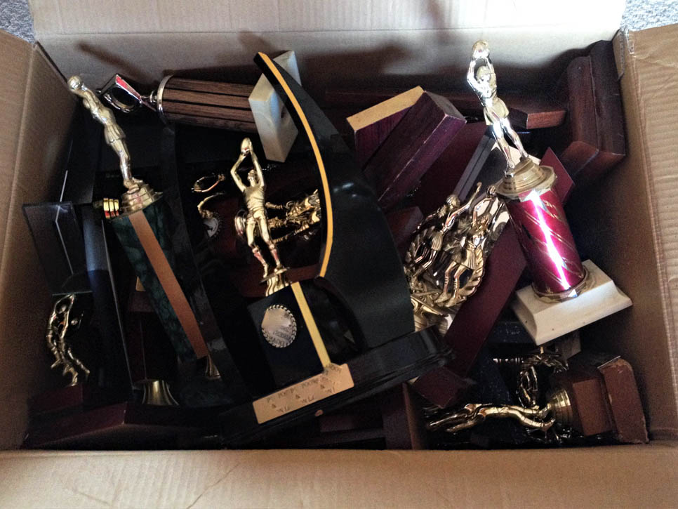 A box full of old sports trophies